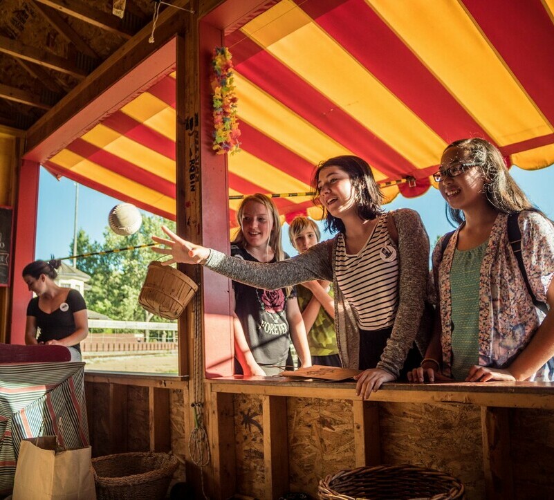 a group of three females playing a carnival game at Fort Edmonton